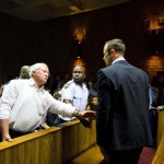 South African "Blade Runner" Oscar Pistorius talks to his father Henke after his court appearance in Pretoria