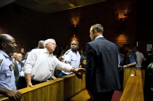 South African "Blade Runner" Oscar Pistorius talks to his father Henke after his court appearance in Pretoria