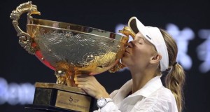 Caroline Wozniacki besa el trofeo que la acredita como campeona del Abierto de China tras vencer a la letona Anastasija Sevastova en la final de mujeres en Beijing. (AP Foto Mark Schiefelbein)